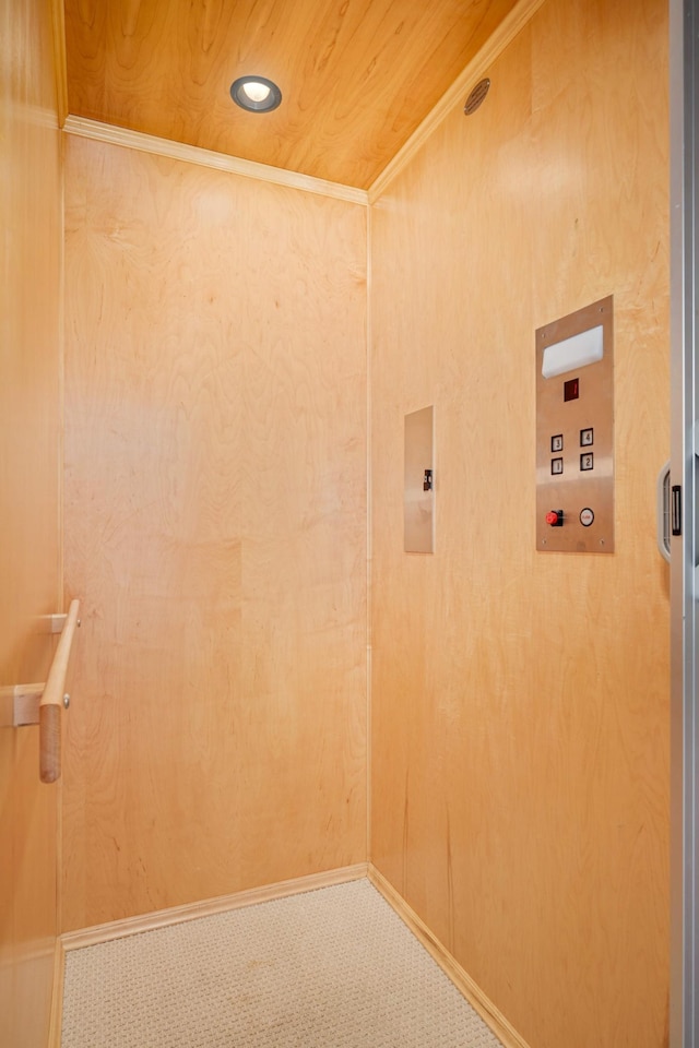 washroom with wood ceiling, wooden walls, elevator, and carpet floors