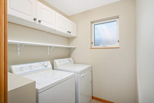 washroom with washing machine and clothes dryer and cabinets