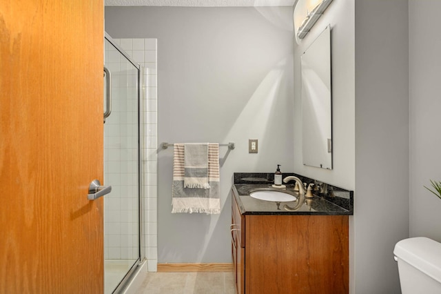 bathroom featuring vanity, toilet, tile patterned floors, and a shower with shower door