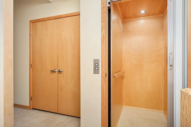 hall with elevator and light tile patterned floors