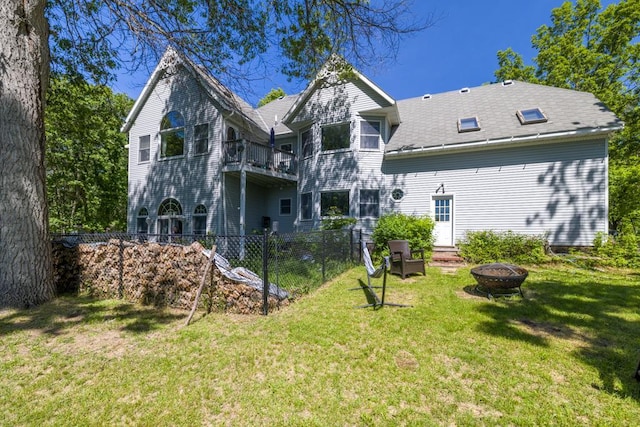 back of house with a yard and a fire pit