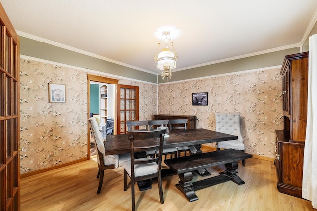 dining room featuring french doors, light hardwood / wood-style flooring, and ornamental molding