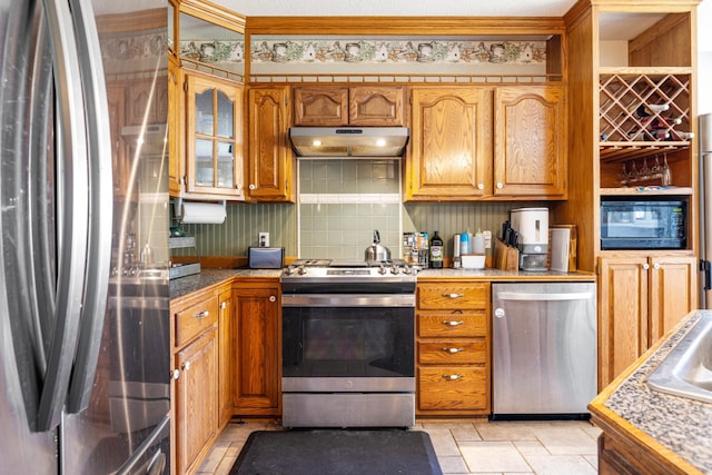39050 Twin Lakes Rd, Menahga, MN 56464 - kitchen with brown cabinets, decorative backsplash, appliances with stainless steel finishes, and under cabinet range hood