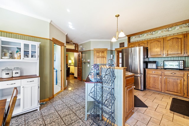 39050 Twin Lakes Rd, Menahga, MN 56464 - kitchen with brown cabinets, an island with sink, freestanding refrigerator, decorative light fixtures, and ornamental molding