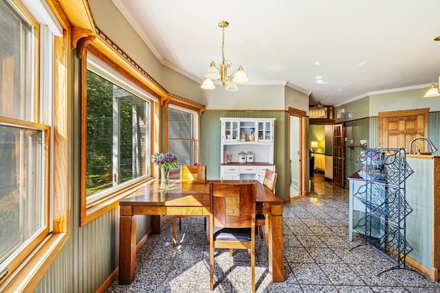 tiled dining space featuring a notable chandelier and crown molding