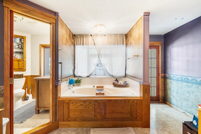 bathroom featuring tile patterned floors, toilet, a wealth of natural light, and a bathtub