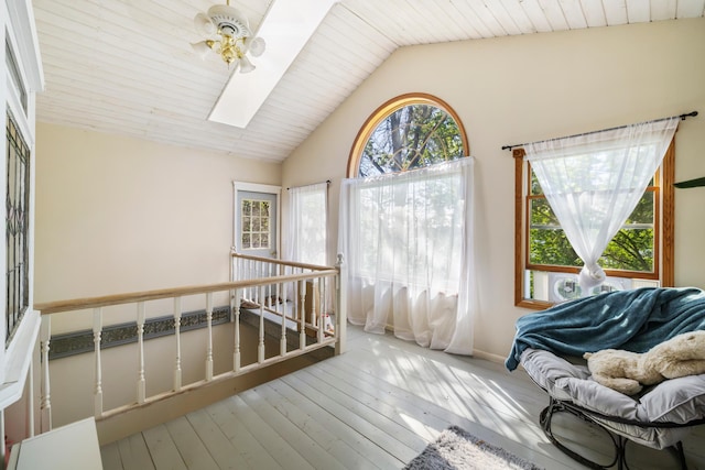 sunroom / solarium featuring a wealth of natural light, vaulted ceiling with skylight, and ceiling fan