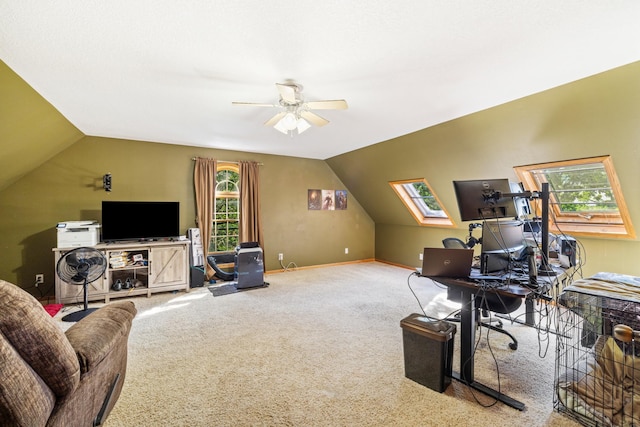 carpeted office space with vaulted ceiling with skylight and ceiling fan