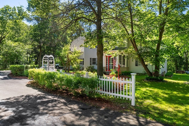 view of property hidden behind natural elements featuring a front yard