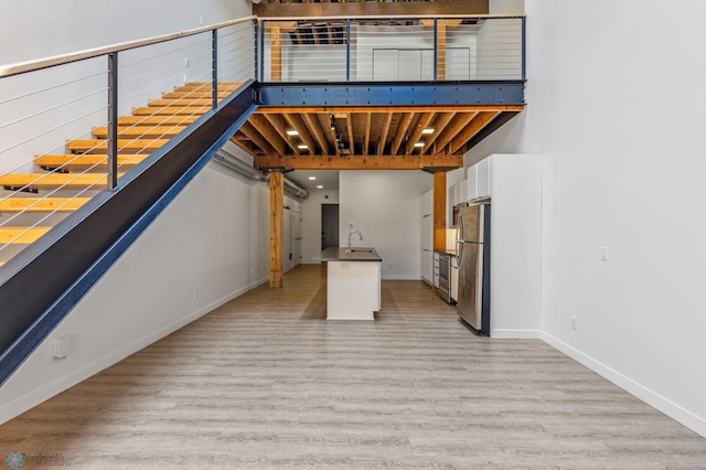 interior space with stainless steel fridge, light wood-type flooring, and sink