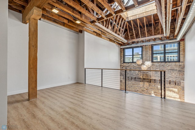 interior space featuring wood-type flooring and brick wall