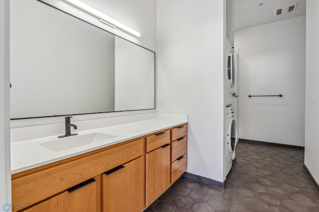 bathroom featuring tile patterned floors, vanity, and stacked washing maching and dryer