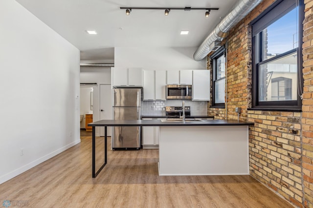 kitchen featuring white cabinets, sink, appliances with stainless steel finishes, and light hardwood / wood-style flooring