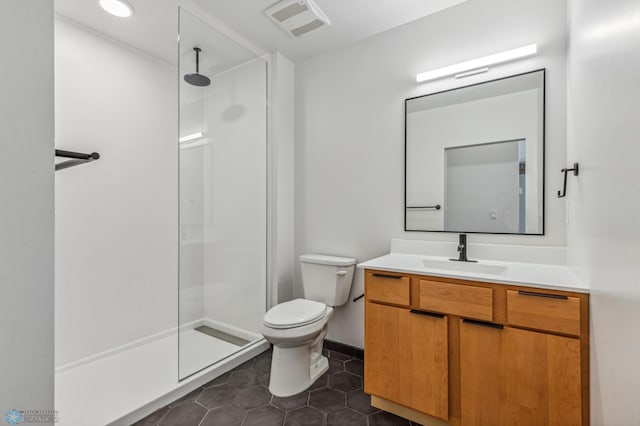 bathroom featuring tile patterned floors, vanity, toilet, and walk in shower