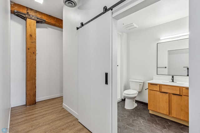 bathroom featuring vanity, wood-type flooring, and toilet