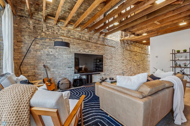 living room featuring beamed ceiling and brick wall