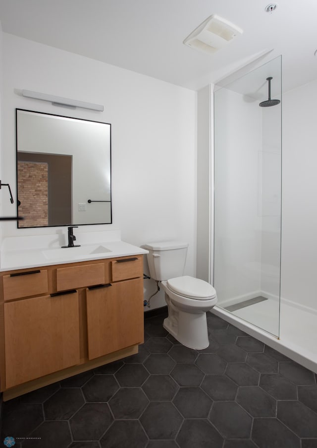 bathroom with a shower, tile patterned flooring, vanity, and toilet