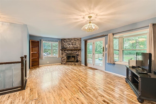 living room with a fireplace, a chandelier, and light wood-type flooring