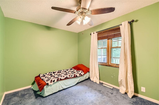 bedroom featuring ceiling fan, carpet, and a textured ceiling