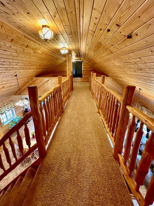 corridor with carpet, lofted ceiling, wooden walls, and wood ceiling