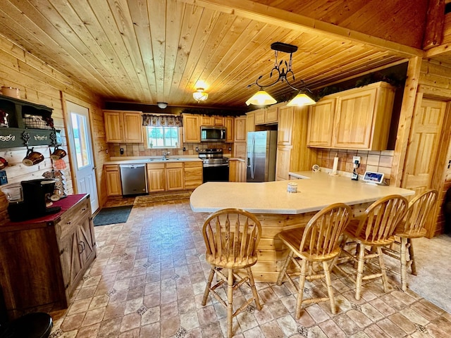 kitchen featuring wood walls, decorative backsplash, decorative light fixtures, stainless steel appliances, and kitchen peninsula