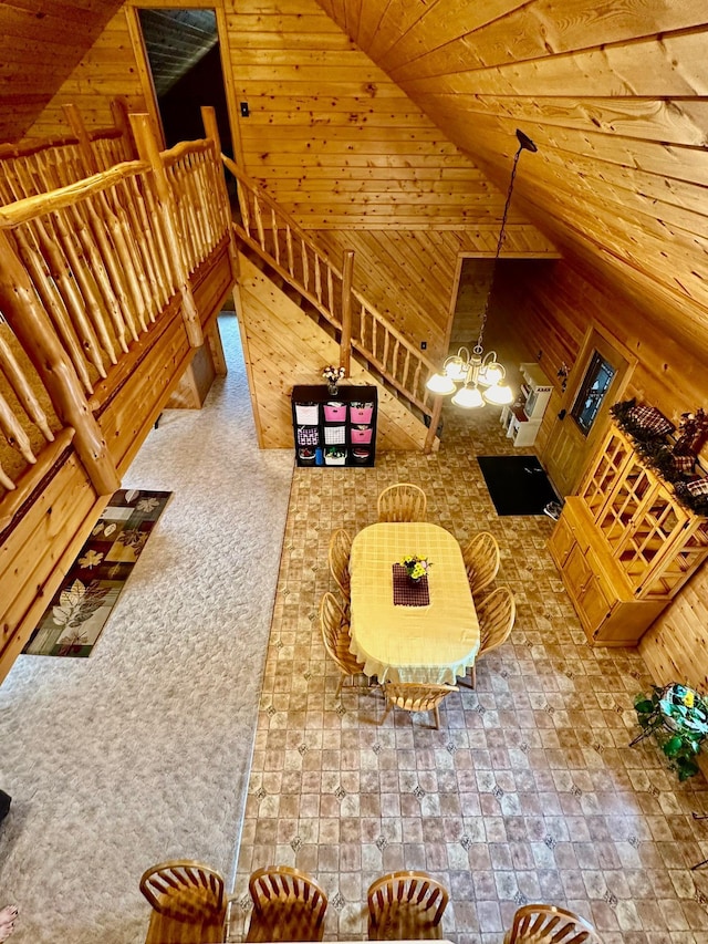 living area featuring wood ceiling, wooden walls, and lofted ceiling