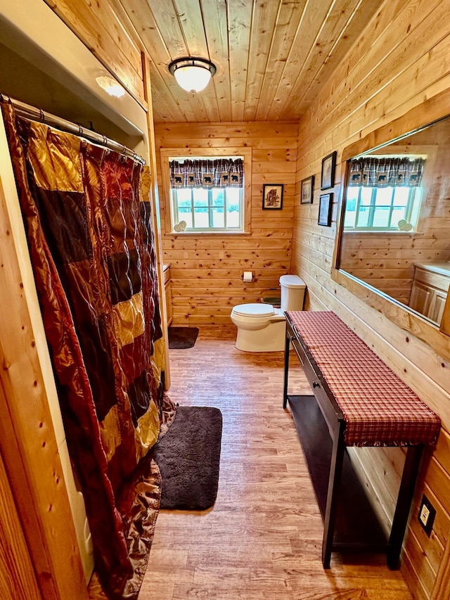 bathroom with wood ceiling, toilet, wood finished floors, and wooden walls