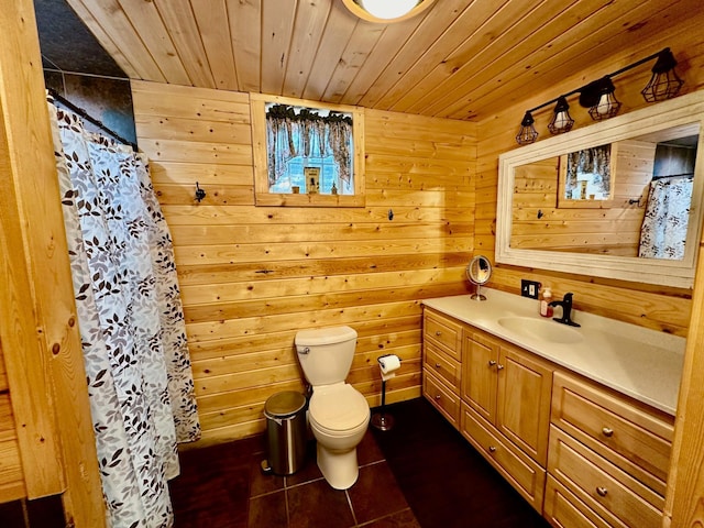 bathroom with vanity, toilet, wood walls, wooden ceiling, and tile patterned flooring