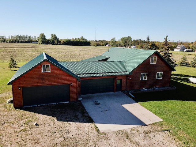 log cabin featuring a rural view, a garage, and a front yard