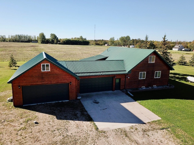 view of front of home featuring metal roof, driveway, log veneer siding, a front yard, and a garage