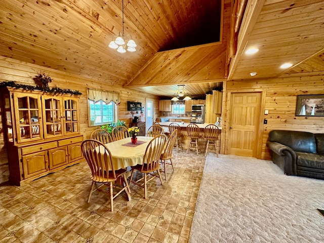 dining room with a notable chandelier, high vaulted ceiling, wooden walls, and wood ceiling