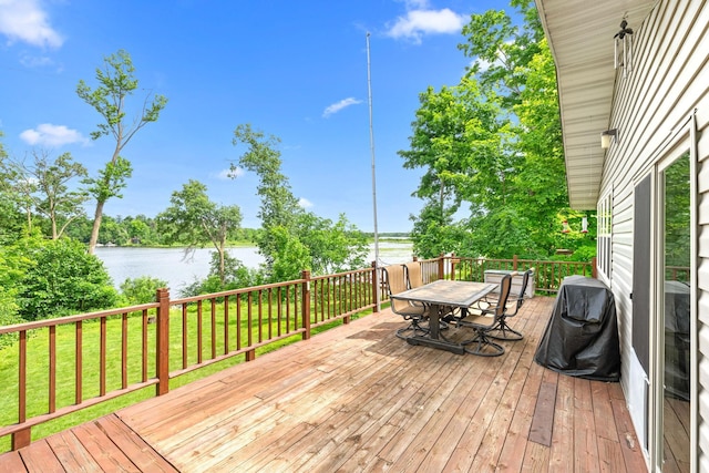 deck featuring a water view, a grill, and a lawn