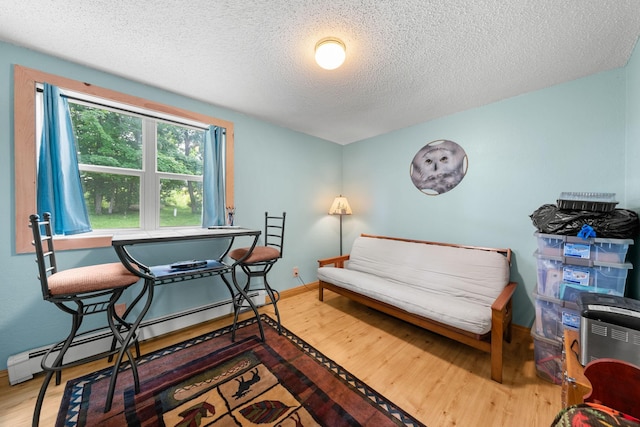 1738 White Ash Dr Unit A, Balsam Lake, WI 54810 - sitting room featuring a baseboard heating unit, a textured ceiling, baseboards, and wood finished floors