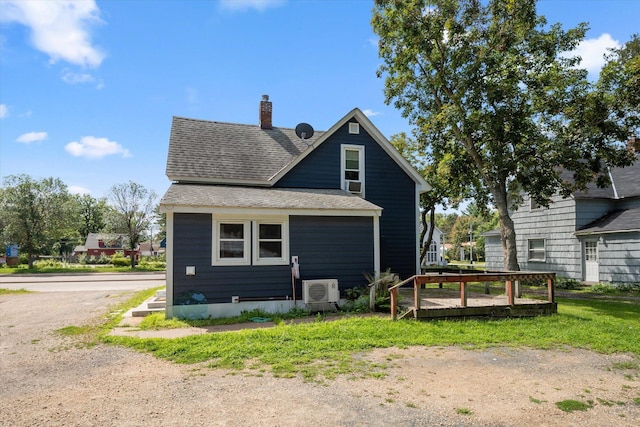 back of property featuring a shingled roof and a chimney