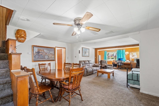 carpeted dining space featuring a ceiling fan, visible vents, and stairway