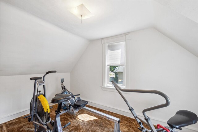 workout area featuring lofted ceiling and baseboards