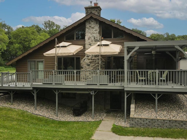 back of house with a lawn, ceiling fan, and a wooden deck