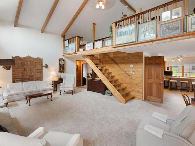 carpeted living room with high vaulted ceiling and beamed ceiling