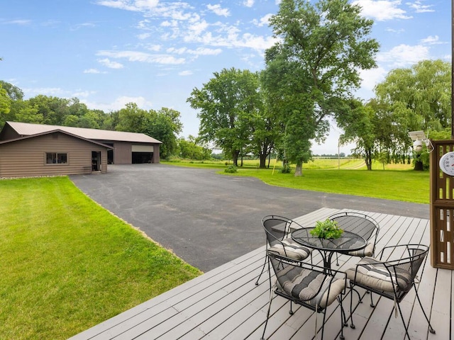 deck with an outbuilding, a garage, and a lawn