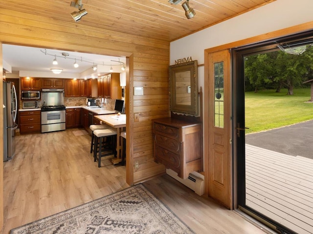 kitchen featuring sink, wooden ceiling, pendant lighting, stainless steel appliances, and light hardwood / wood-style floors