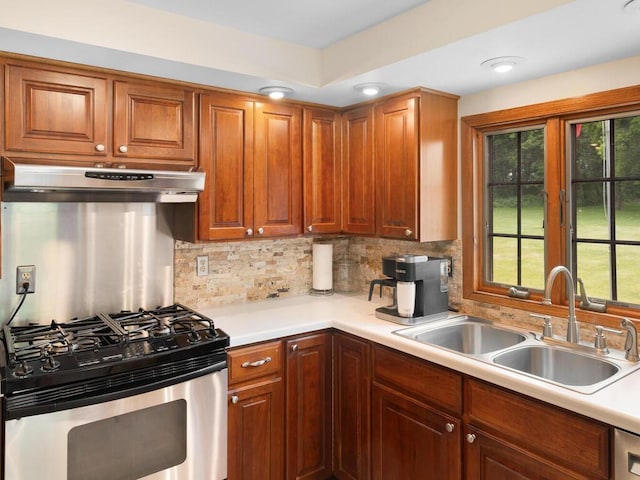 kitchen with tasteful backsplash, sink, and stainless steel gas range oven