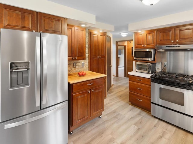 kitchen featuring tasteful backsplash, light hardwood / wood-style flooring, and appliances with stainless steel finishes