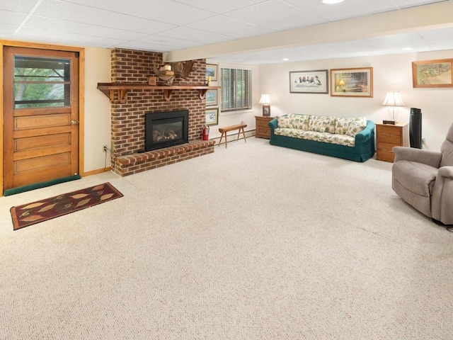 living room with a paneled ceiling, a brick fireplace, and carpet