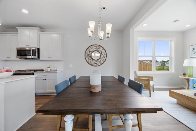 dining room featuring recessed lighting, baseboards, an inviting chandelier, and wood finished floors