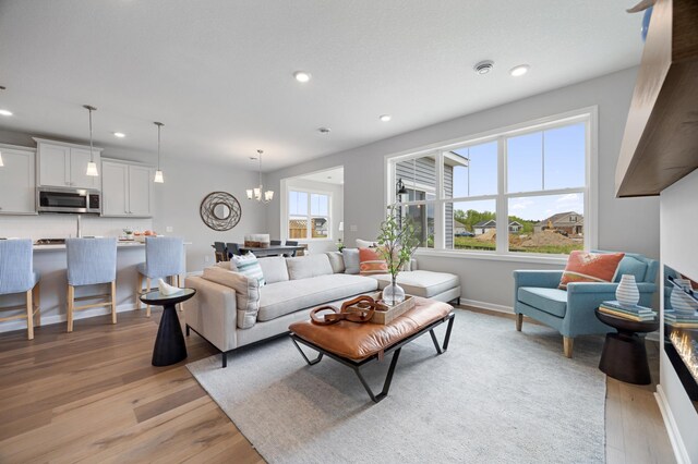 living room featuring a notable chandelier and light wood-type flooring