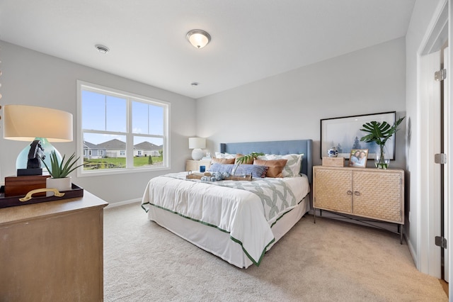 bedroom with baseboards and light carpet