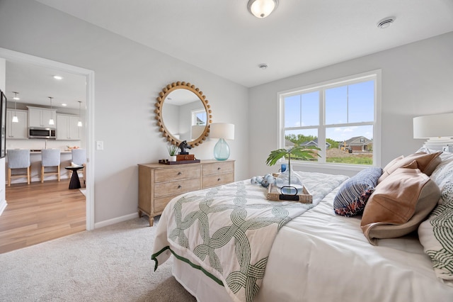 bedroom with baseboards and light carpet