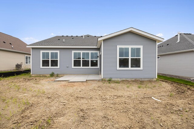 rear view of property featuring a patio and a shingled roof