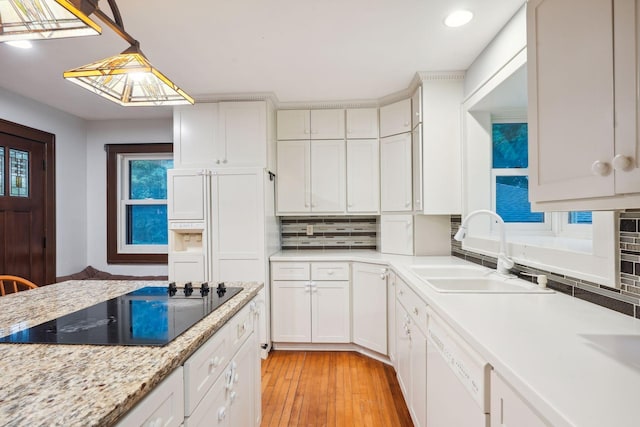 kitchen featuring sink, hanging light fixtures, black electric cooktop, dishwasher, and white cabinets