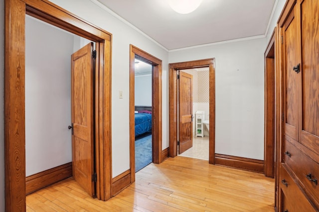 hallway featuring ornamental molding and light wood-type flooring